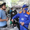 Nhân viên Petrolimex đang bán xăng cho khách hàng. (Ảnh: Đức Duy/Vietnam+)