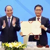 Thủ tướng Nguyễn Xuân Phúc và Bộ trưởng Công Thương Trần Tuấn Anh tại Lễ ký Hiệp định Đối tác Kinh tế Toàn diện Khu vực RCEP. (Ảnh: TTXVN)
