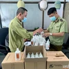 Lực lượng Quản lý thị trường Hà Nội thu giữ nước sát khuẩn có dấu hiệu giả mạo thương hiệu. (Ảnh: PV/Vietnam+)