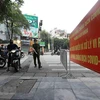 Công an phường Bách Khoa kiểm tra người tham gia giao thông tại chốt phòng, chống dịch trên tuyến phố Lê Thanh Nghị. (Ảnh: TTXVN)