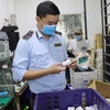 Lực lượng Quản lý thị trường Hà Nội kiểm tra cơ sở gia công, lắp ráp sạc điện thoại, ipad giả mạo nhãn hiệu. (Ảnh: PV/Vietnam+)