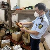 Cán bộ Đội Quản lý thị trường số 24 đang kiểm tra số mật ong vừa tạm giữ tại một cơ sở trên địa bàn huyện Hoài Đức, Hà Nội. (Ảnh: PV/Vietnam+)