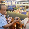 Ông Trần Hữu Linh, Tổng Cục trưởng Tổng cục Quản lý thị trường hướng dẫn cách nhận biết một số sản phẩm bị làm giả. (Ảnh: Minh Anh/Vietnam+)