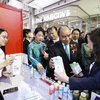 Chủ tịch nước Nguyễn Xuân Phúc thăm gian hàng của Tập đoàn TH tại "Tuần lễ hàng Việt Nam tại Thái Lan" ngày 17/11. (Ảnh: TTXVN)