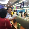 Ông Trần Hữu Linh, Tổng cục trưởng Tổng cục Quản lý thị trường hướng dẫn phân biệt hóa mỹ phẩm giả. (Ảnh: Xuân Quảng/Vietnam+)