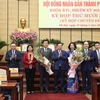 Bí thư Thành ủy Hà Nội Đinh Tiến Dũng tặng hoa chúc mừng bà Vũ Thu Hà (áo dài xanh) được bầu làm Phó Chủ tịch Ủy ban Nhân dân thành phố Hà Nội. (Ảnh: PV/Vietnam+)