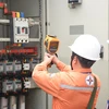 Nhân viên EVNHANOI kiểm tra vận hành thiết bị điện. (Ảnh: PV/Vietnam+)