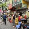 Cơ quan chức năng phường Nguyễn Du, quận Hai Bà Trưng tuyên truyền việc sắp xếp vỉa hè cho các hộ kinh doanh. (Ảnh: Xuân Quảng/Vietnam+)