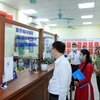 Chủ tịch Ủy ban Nhân dân quận Hai Bà Trưng Nguyễn Quang Trung kiểm tra tại bộ phận một cửa phường Bạch Mai. (Ảnh: Xuân Quảng/Vietnam+)