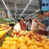 Người tiêu dùng mua sắm hàng hóa tại siêu thị. (Ảnh: Đức Duy/Vietnam+)