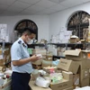 Lực lượng Quản lý Thị trường kiểm tra hàng hóa tại cơ sở thuộc phương Yên Nghĩa, quận Hà Đông, Hà Nội. (Ảnh: PV/Vietnam+)