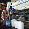 Người dân Khu Đô thị Thanh Hà lấy nước từ xe chở nước sạch. (Ảnh: Hoàng Hiếu/TTXVN)