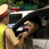 Cảnh sát Giao thông kiểm tra nồng độ cồn của lái xe. (Ảnh: TTXVN)