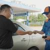Nhân viên Petrolimex xuất hóa đơn bán lẻ xăng dầu cho khách hàng. (Ảnh: Đức Duy/Vietnam+)