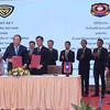Tổng Cục trưởng Tổng cục Quản lý Thị trường Trần Hữu Linh và Vụ trưởng Vụ Cạnh tranh kinh doanh và Kiểm tra Thương mại Lào triển khai ký cam kết trong lĩnh vực quản lý thị trường. (Ảnh: PV/Vietnam+)
