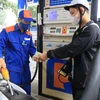 Nhân viên Petrolimex bán xăng cho khách hàng. (Ảnh: Đức Duy/Vietnam+)