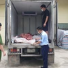 Lực lượng chức năng kiểm tra xe ôtô chở xương và lòng lợn không rõ nguồn gốc. (Ảnh: PV/Vietnam+)