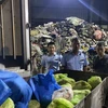Lực lượng Quản lý Thị trường tỉnh Hải Dương giám sát tiêu hủy thực phẩm không rõ nguồn gốc. (Ảnh: PV/Vietnam+)