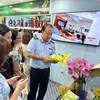 Ông Trần Hữu Linh, Tổng cục trưởng Tổng cục Quản lý thị trường hướng dẫn phân biệt một số loại gạo được bảo hộ thương hiệu. (Ảnh: Đức Duy/Vietnam+)