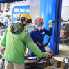 Nhân viên Petrolimex bán xăng cho khách hàng. (Ảnh: Đức Duy/Vietnam+)