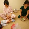 Chị Tuyết cùng bé 10 ngày tuổi may mắn thoát ra từ đám cháy tầng cao chung cư HH4a Linh Đàm. (Ảnh: Minh Sơn/Vietnam+)