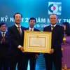 Bộ trưởng Bộ Xây dựng Phạm Hồng Hà đã trực tiếp trao bằng khen và cờ thi đua do Chủ tịch nước tặng thưởng tới ban lãnh đạo Công ty CDC. (Ảnh: Võ Phương/Vietnam+)