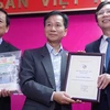 Nhà báo Lê Quốc Trung - Nguyên Tổng giám đốc Thông tấn xã Việt Nam (giữa) trao tặng hiện vật tới Bảo tàng Báo chí Việt Nam. (Ảnh: Võ Phương/Vietnam+)
