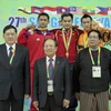 Bộ trưởng Hoàng Tuấn Anh (giữa, hàng trước) trao huy chương cho vận động viên Phạm Quốc Khánh (giữa, hàng sau). (Ảnh: Quang Nhựt/TTXVN)