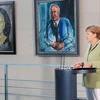 Thủ tướng Đức Angela Merkel phát biểu trong một hội nghị ở Phủ Thủ tướng tại Berlin, bên cạnh lần lượt là ảnh chân dung cựu Thủ tướng Helmut Kohl và cựu Thủ tướng Gerhard Schröder (trái). (Ảnh: Mạnh Hùng/Vietnam+)