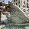 Một du khách đang hứng nước từ đài phun nước Barcaccia ở quảng trường Tây Ban Nha, trung tâm thủ đô Rome. (Nguồn: ANSA)