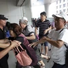 Người nhà nạn nhân trên chuyến bay MH370 xông vào văn phòng chi nhánh Malaysia Airlines ở Bắc Kinh ngày 5/8. (Nguồn: QQ)