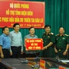 Trung tướng Dương Đức Hòa, Ủy viên Trung ương Đảng, Tư lệnh Quân khu trao tượng trưng số tiền 1 tỷ đồng cho tỉnh Điện Biên. (Ảnh: Xuân Tư​/TTXVN)