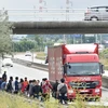 Cảnh sát chống bạo động Pháp gác dọc theo tuyến đường bộ dẫn tới cảng tàu ở Calais nhằm ngăn người di cư trái phép xâm nhập. (Nguồn: AFP/TTXVN)