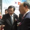 Đại sứ Phạm Hữu Chí giới thiệu cho các đại biểu Hàn Quốc tham quan triển lãm. (Ảnh: Phạm Duy/Vietnam+)