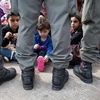 Trẻ em tỵ nạn ngồi đợi cùng người thân ở biên giới Áo-Hungary ngày 20/9. (Nguồn: AFP)
