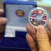 Đồng xu kỷ niệm in hình quốc kỳ của các nước ASEAN tại Ngân hàng quốc gia Campuchia ở Phnom Penh ngày 25/12/2015. (Nguồn: THX/TTXVN)