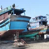 Ngư dân Quảng Trị sửa chữa tàu thuyền chuẩn bị cho mùa đánh bắt cá. (Ảnh: Hồ Cầu/TTXVN)