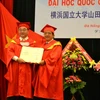 Giáo sư, tiến sỹ Hitoshi Yamada (trái) nhận danh hiệu tiến sỹ danh dự Đại học Đà Nẵng. (Ảnh: Đinh Văn Nhiều/TTXVN)