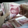 Kiểm tiền mệnh giá 100 nhân dân tệ tại chi nhánh ngân hàng ở Hoài Bắc, tỉnh An Huy, Trung Quốc. (Nguồn: EPA/TTXVN)