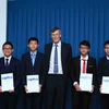 Ông Mike Clapper, Giám đốc điều hành Hội toán học Australia, trao giải thưởng cho học sinh Việt Nam đạt điểm 4 trong 41 giải thưởng toàn cầu Cuộc thi Olympic Toán học Australia dành cho học sinh trung học cơ sở (AIMO). (Ảnh: Quý Trung/TTXVN)