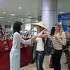 Các du khách Nga nhận món quà chiếc nón lá Việt Nam. (Ảnh: Tiên Minh/TTXVN)