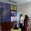 Lãnh đạo các đơn vị xem thông tin về chất lượng môi trường trên bảng thông tin giao thông điện tử. (Ảnh: Hoàng Hải/Vietnam+)