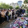 Người dân đặt hoa và thắp nến tại lễ tưởng niệm các nạn nhân vụ tấn công khủng bố ở Manchester. (Nguồn: THX/TTXVN)