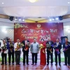 Đồng chí Saysomphone Phomvihane (giữa), Ủy viên Bộ Chính, Chủ tịch Mặt trận Lào Xây dựng Đất nước, cùng các quan khách chụp ảnh lưu niệm với các thành viên Ban Chấp hành Tổng hội Người Việt Nam tại Lào. (Ảnh: Phạm Kiên/TTXVN)