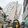 Lực lượng cứu hộ làm nhiệm vụ tại khu vực một tòa nhà bị đổ nghiêng sau trận động đất ở Đài Loan, Trung Quốc ngày 7/2. (Nguồn: Kyodo/TTXVN) 