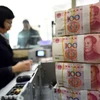 Kiểm tiền 100 tệ tại ngân hàng ở Liên Vận Cảng, tỉnh Giang Tô, Trung Quốc. (Nguồn: AFP/TTXVN)