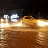 Các phương tiện di chuyển trên mặt đường Phạm Văn Đồng, quận Cầu Giấy bị ngập nước tối 15/7. (Ảnh: Văn Điệp/TTXVN)