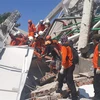 Lực lượng cứu hộ tìm kiếm nạn nhân trong đống đổ nát của một tòa nhà bị sập sau thảm họa động đất, sóng thần tại tỉnh Trung Sulawesi, Indonesia ngày 30/9. (Nguồn: AFP/TTXVN)