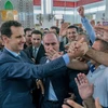 Tổng thống Syria Bashar al-Assad (trái) trong cuộc gặp với người dân tại thành phố Tartous ngày 15/6. (Nguồn: AFP/TTXVN) 