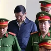 Lực lượng chức năng dẫn giải bị cáo Phan Văn Vĩnh vào tòa. (Ảnh: Trung Kiên/TTXVN) 